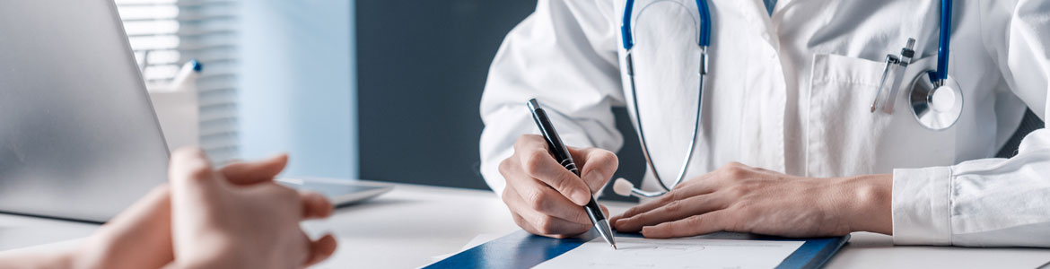 closeup of a female doctors hands writing at a desk