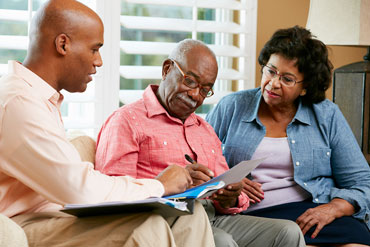 Agent helping senior couple with paperwork