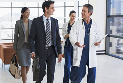 Group of businessmen and women and doctors walking in a lobby