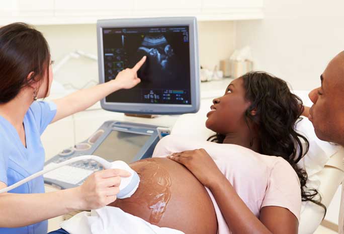 Pregnant woman and doctor looking at ultrasound