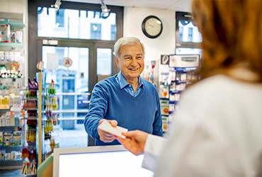 pharmacist giving a piece of paper to a customer