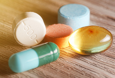 various pills on wooden table
