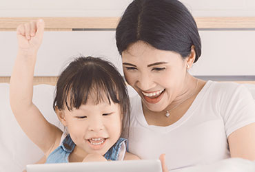 mother and daughter reading on a computer