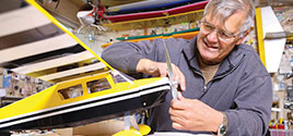 man working on a toy airplane