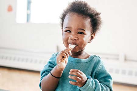 Toddler eating a spoonful of ice cream